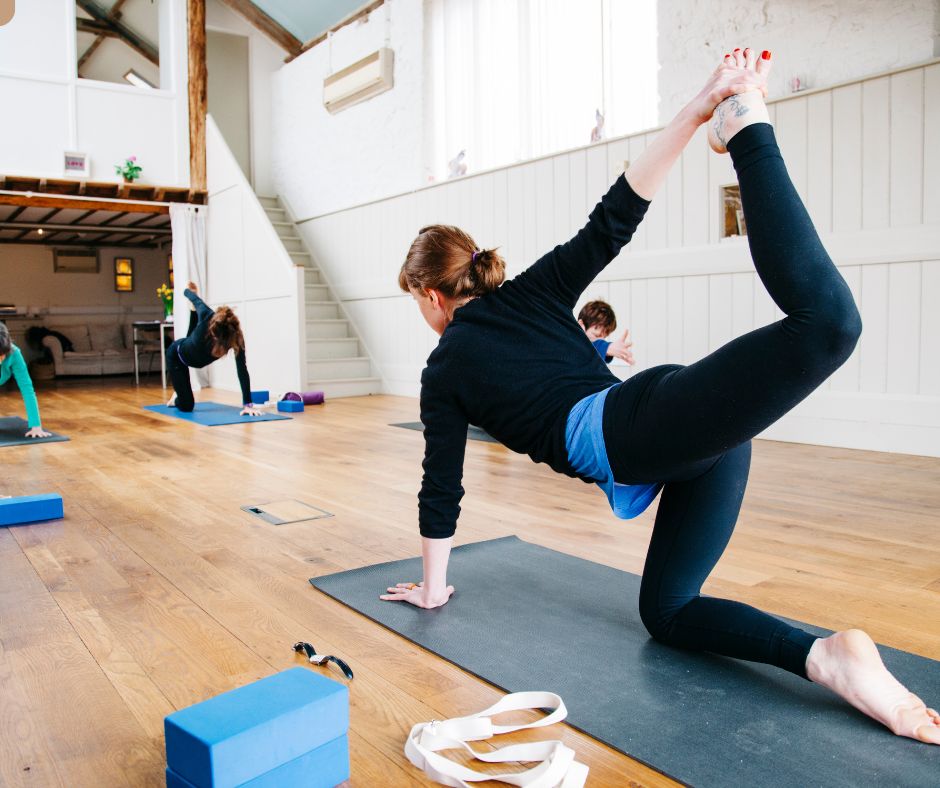 student practicing Vyaghrasana tiger pose